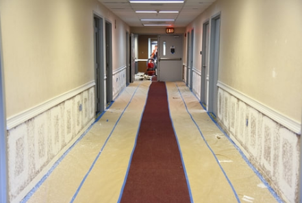 Corridor in a high-rise building that has just been repainted. The painters spread a roll of paper on the floor to protect the carpet. The work was executed by Peintre Victoriaville.