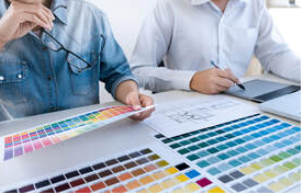 Deux hommes à Victoriaville regardent des palettes de couleurs. Il y a un plan d'architecte sur la table.
